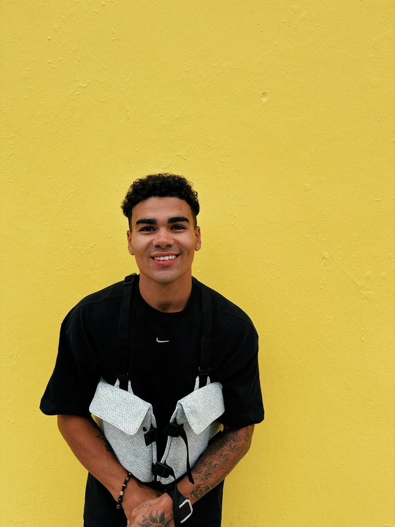 Styles smiling against yellow wall